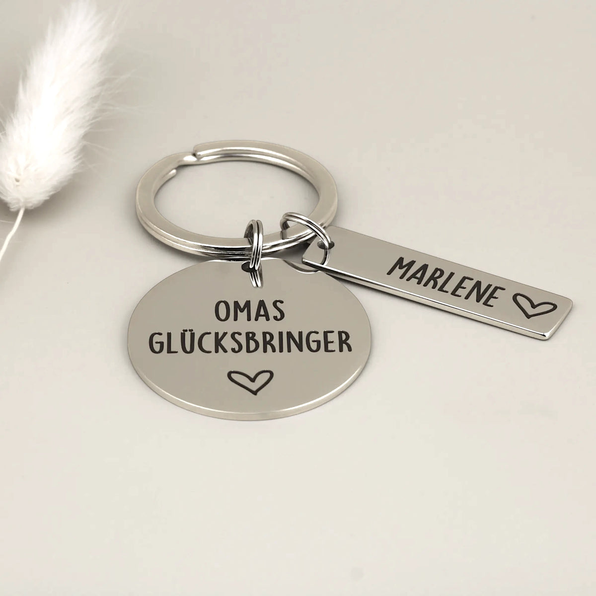 Personalisierter Schlüsselanhänger „Omas Glücksbringer“ aus Edelstahl mit einem Namensanhänger und Herz