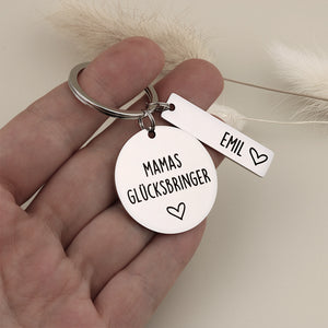 Mamas-Glücksbringer-Schlüsselanhänger mit Namensanhänger Emil als Größenvergleich in einer Hand.