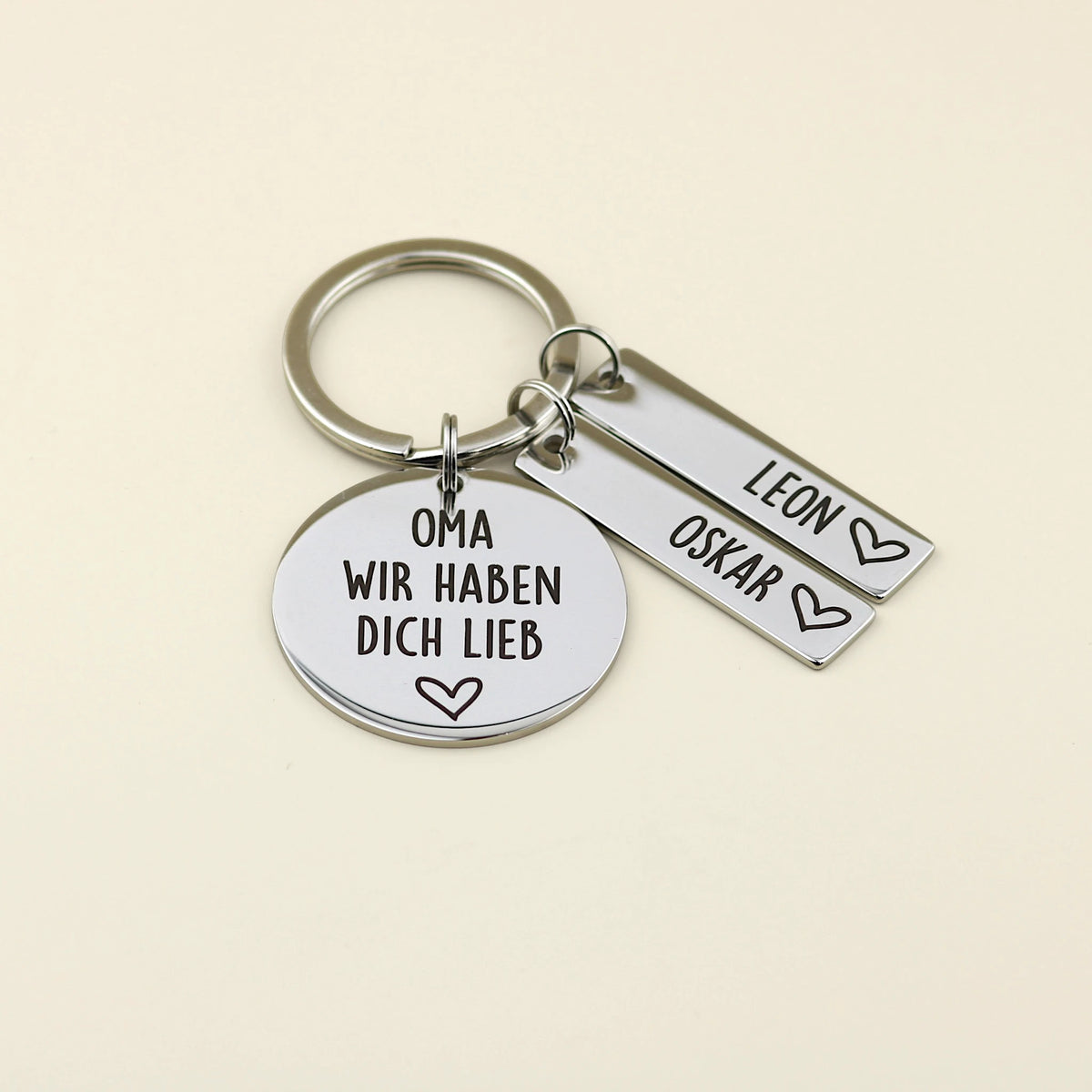 Schlüsselanhänger „Oma, wir haben dich lieb“ mit zwei Namensanhängern für Leon und Oskar.
