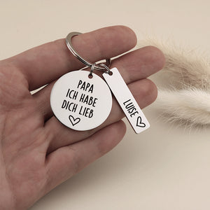 Person hält den personalisierten Papa ich habe dich lieb Schlüsselanhänger mit Namensanhänger Luise als Größenvergleich.