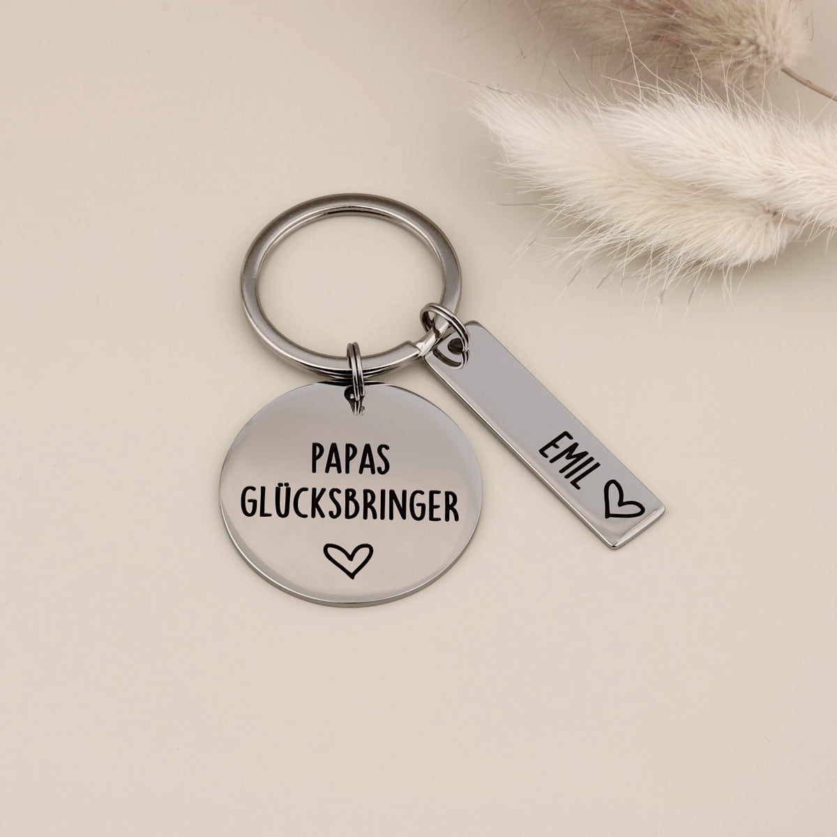 Personalisierter Papas Glücksbringer Schlüsselanhänger mit Namensanhänger Emil und heller Dekoration.