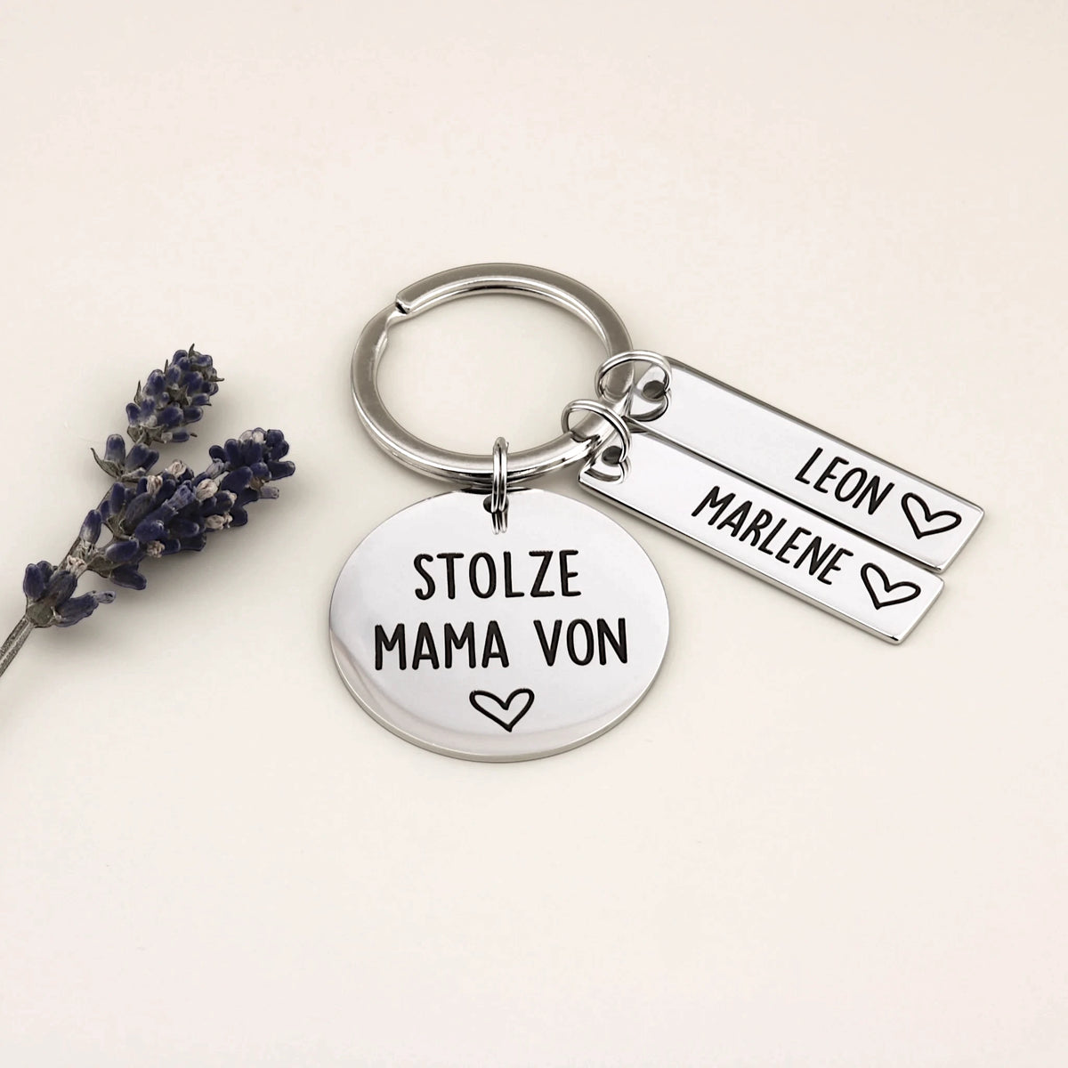Schlüsselanhänger „Stolze Mama von“ mit den Namen Leon und Marlene neben Lavendel.