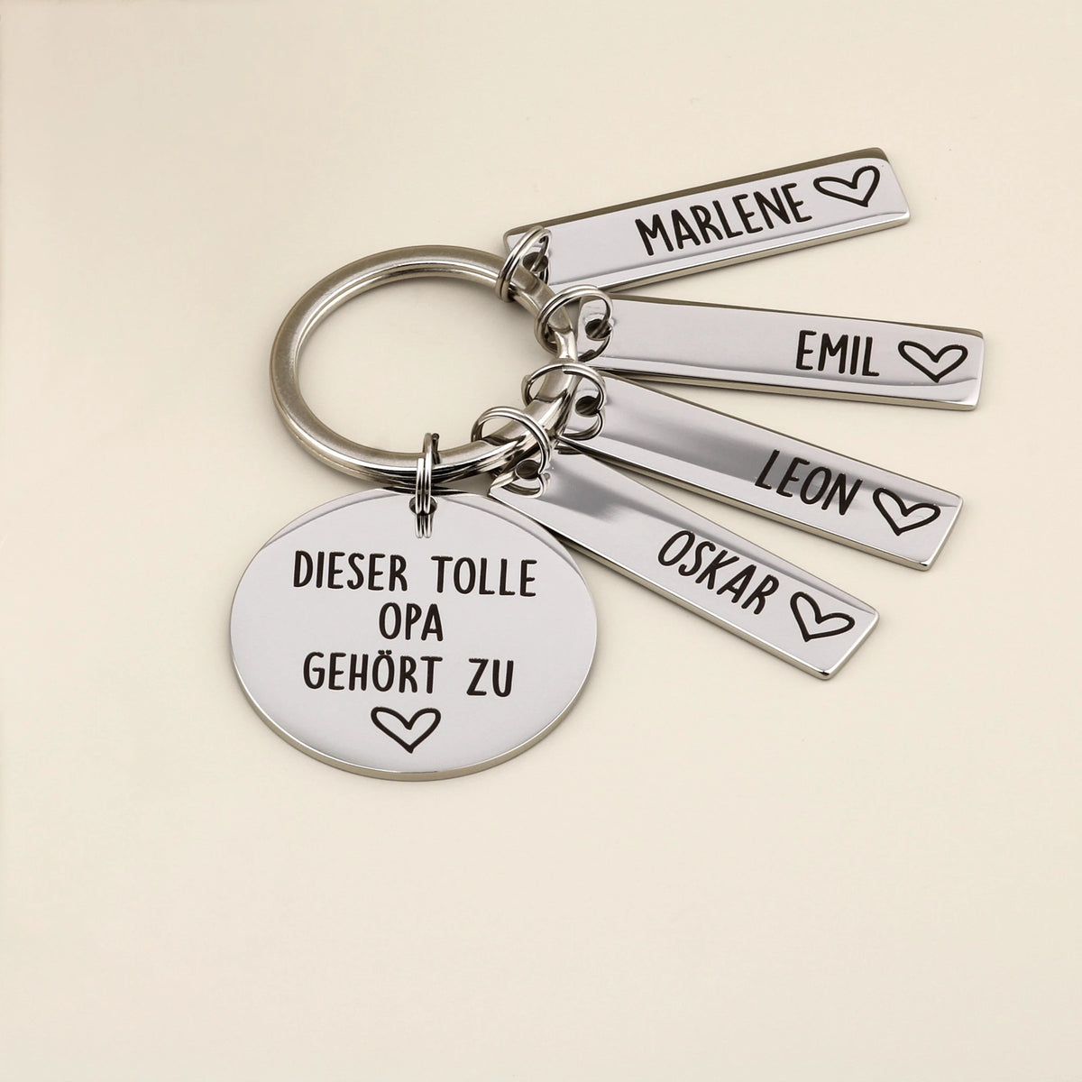 Schlüsselanhänger „Dieser tolle Opa gehört zu“ mit vier Namensanhängern und heller Dekoration.