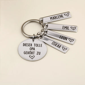 Schlüsselanhänger „Dieser tolle Opa gehört zu“ mit vier Namensanhängern und heller Dekoration.