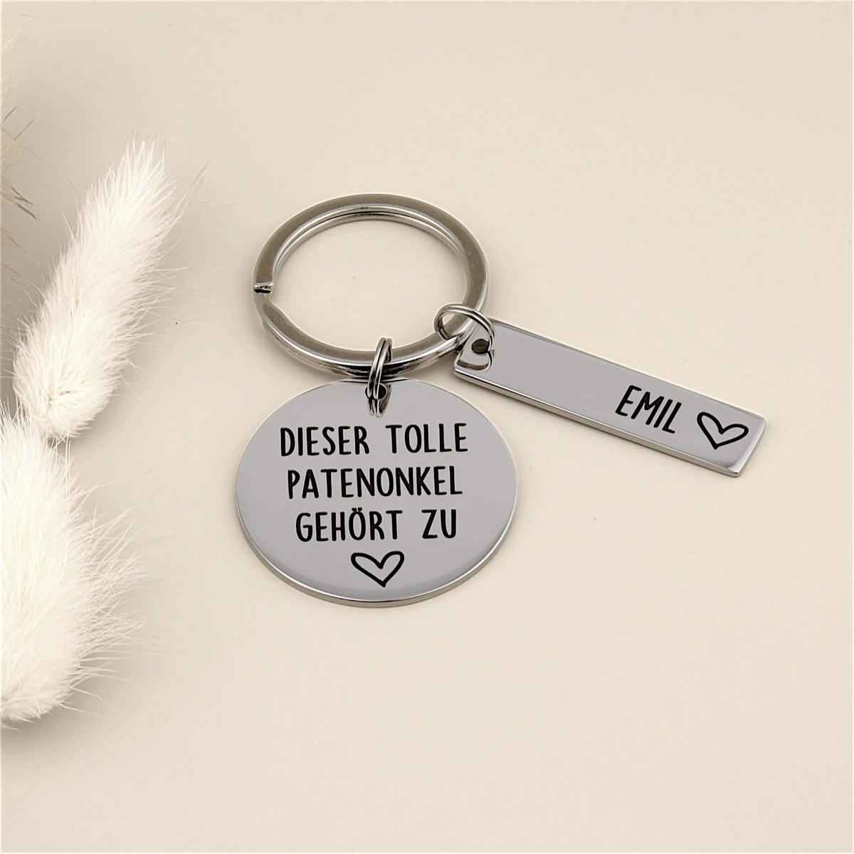 Schlüsselanhänger „Dieser tolle Patenonkel gehört zu“ mit Namensanhänger Emil und heller Dekoration.