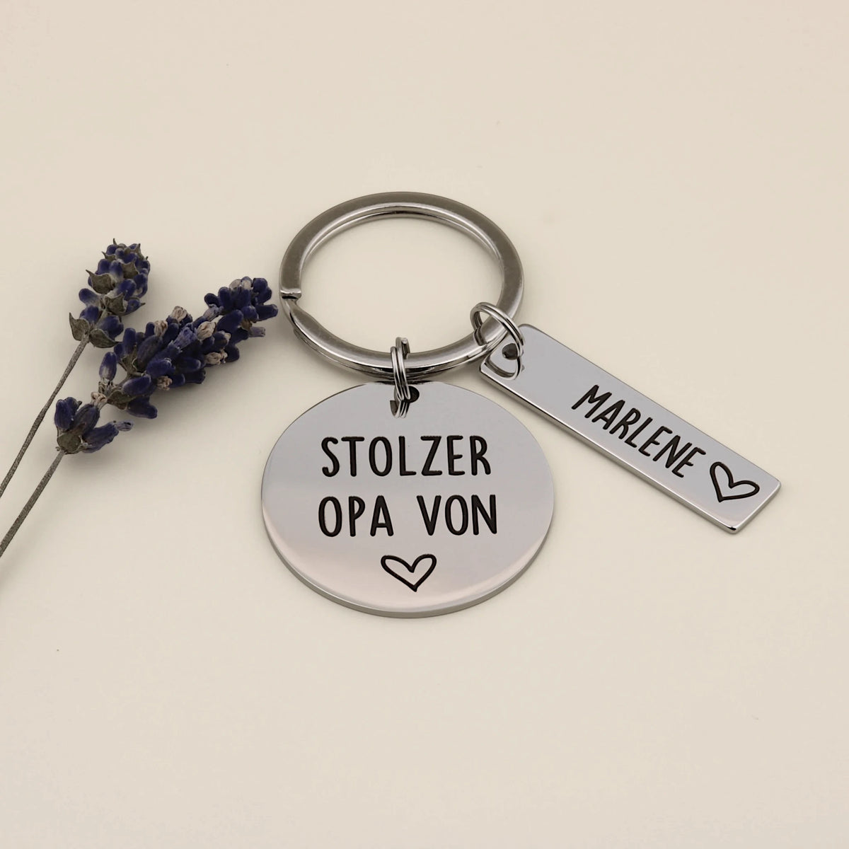 Schlüsselanhänger für Stolzer Opa mit einem Namensanhänger neben Lavendel auf hellem Hintergrund.