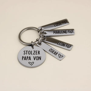 Schlüsselanhänger „Stolzer Papa von“ mit vier Namensanhängern: Luise, Marlene, Leon und Oskar.