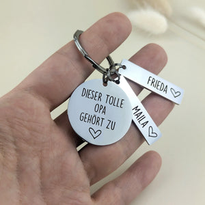 Tolle Opa Schlüsselanhänger mit Namensanhängern in der Hand als Größenvergleich