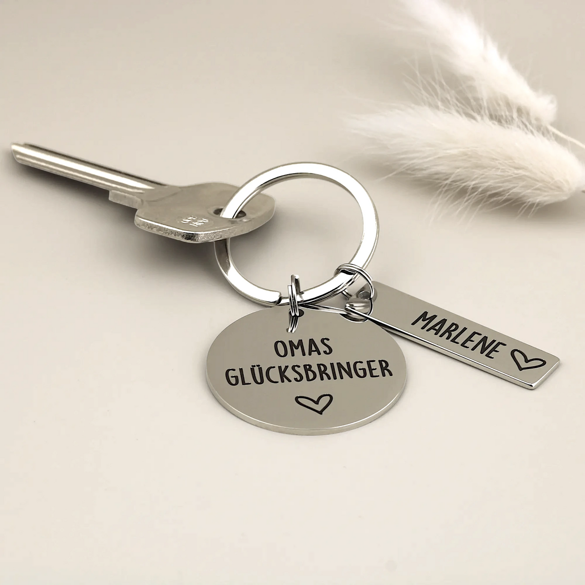 Personalisierter Omas Glücksbringer Schlüsselanhänger mit einem Namen an einem Schlüssel befestigt