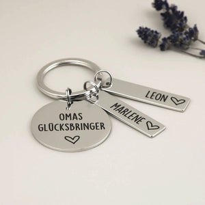 Omas Glücksbringer Schlüsselanhänger mit zwei Namensanhängern und Herz neben Lavendel