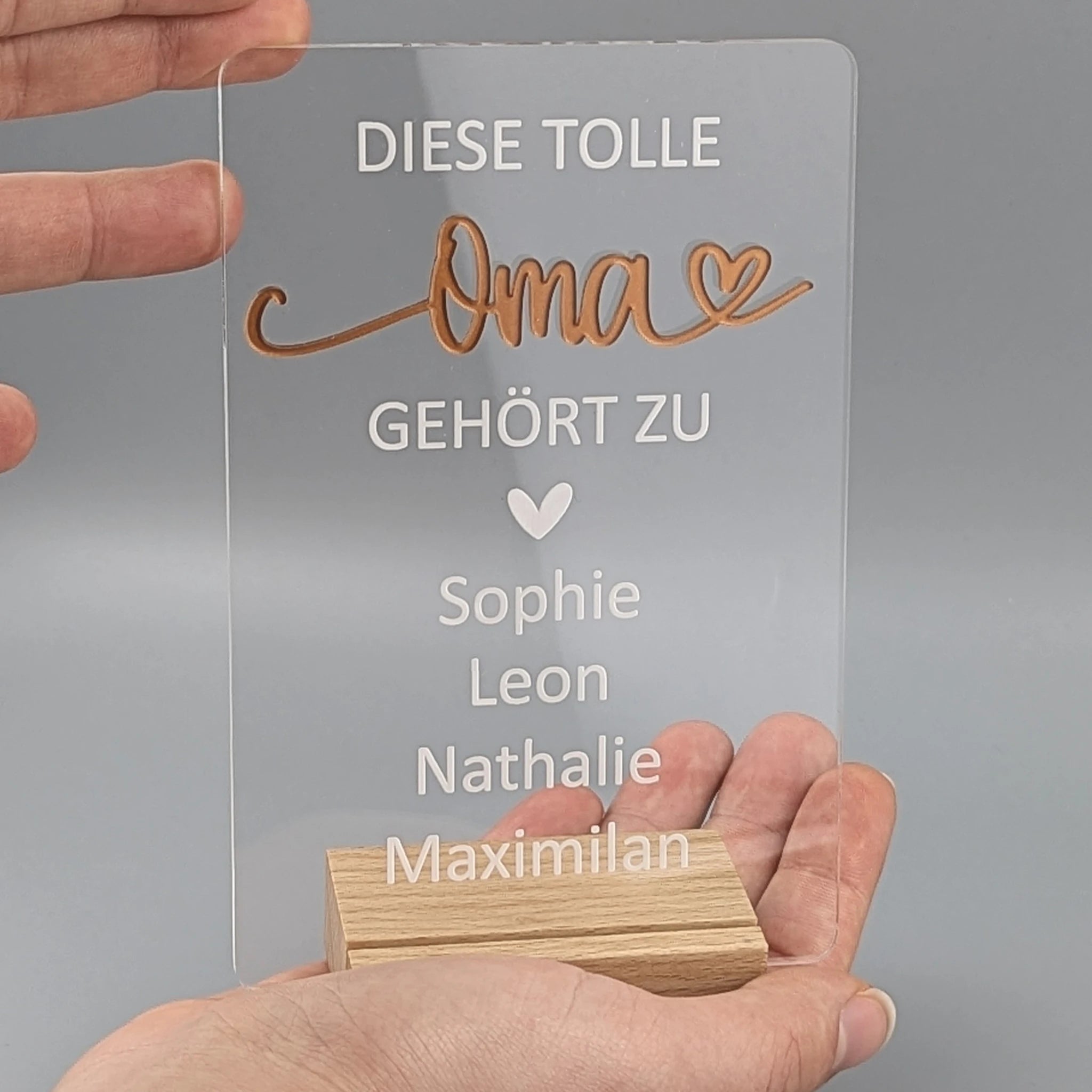 Personalisiertes Geschenk für Oma mit Namen der Enkelkinder – Acrylschild im Holzsockel in der Hand