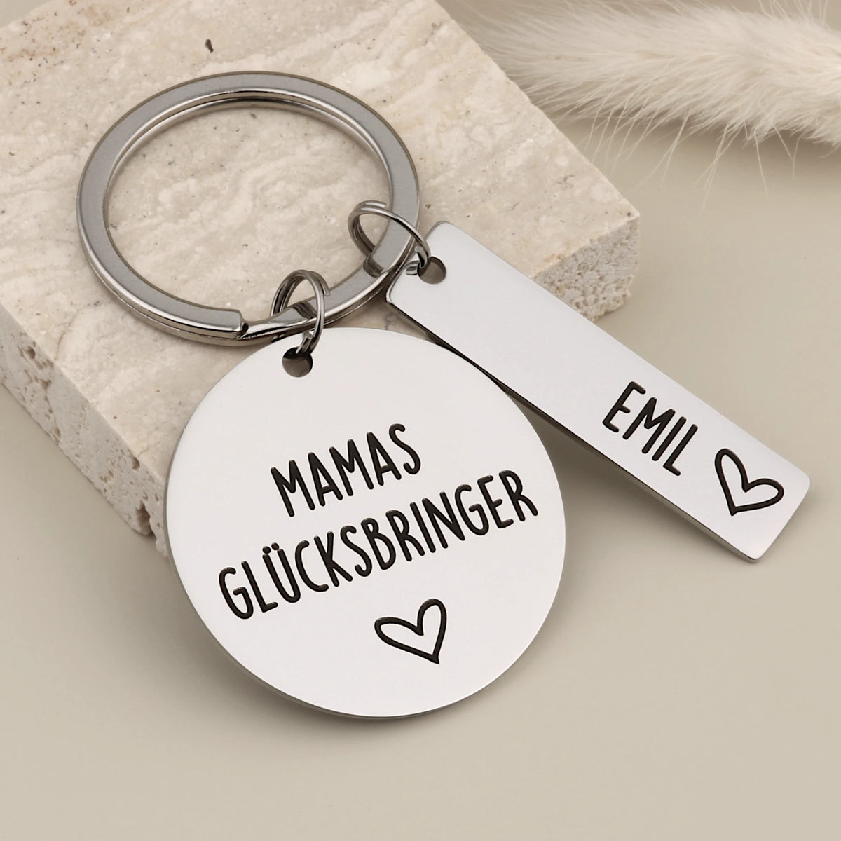 Nahaufnahme des Mamas-Glücksbringer-Schlüsselanhängers mit Namensanhänger Emil.