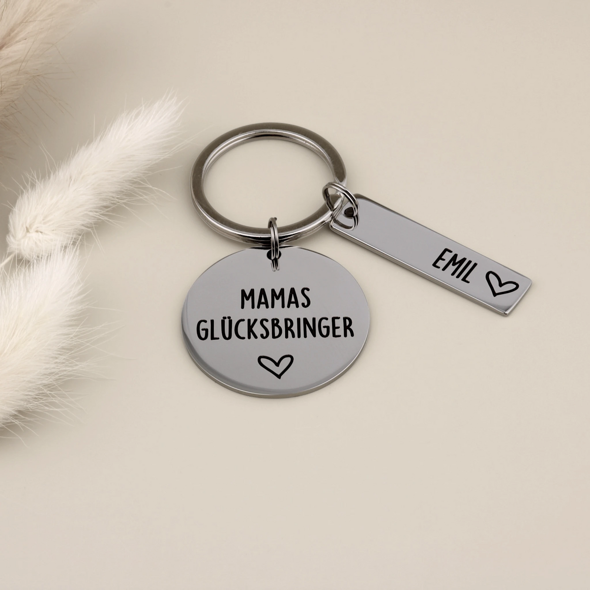 Mamas-Glücksbringer-Schlüsselanhänger mit dem Namensanhänger Emil auf hellem Hintergrund.