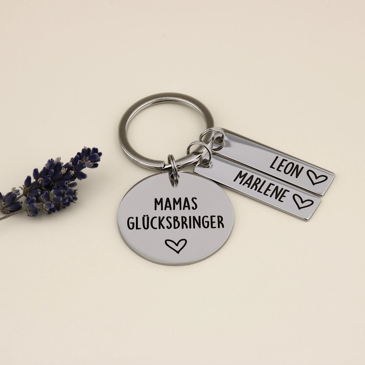 Personalisierter Schlüsselanhänger „Mamas Glücksbringer“ mit zwei Namensanhängern Leon und Marlene.