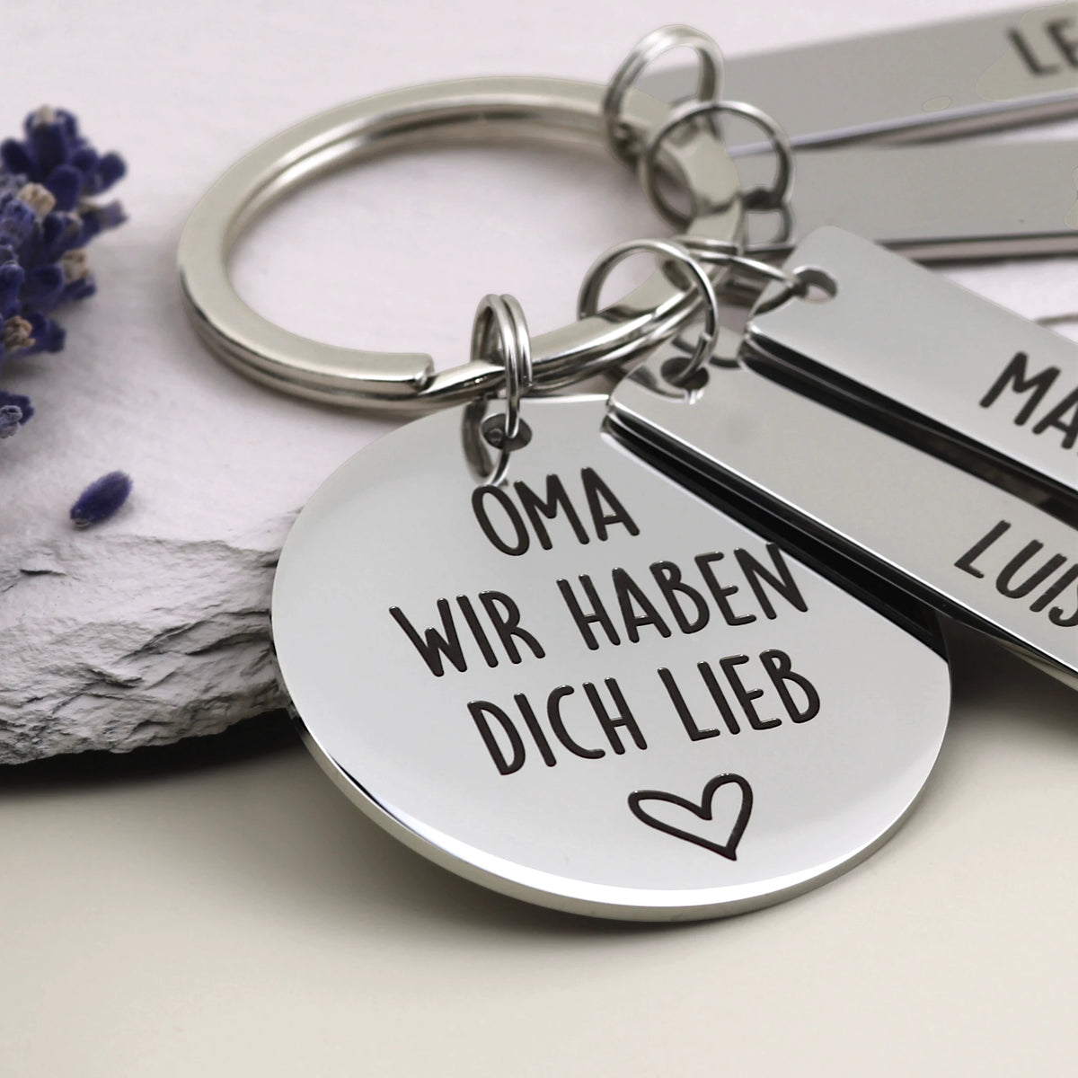 Detailaufnahme des Schlüsselanhängers „Oma, wir haben dich lieb“ mit personalisierten Namensanhängern.