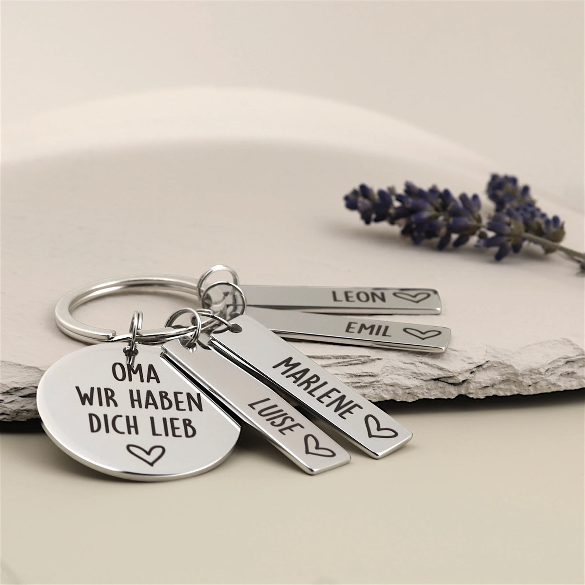 Personalisierter Schlüsselanhänger „Oma, wir haben dich lieb“ mit Namensanhängern in einer Produktansicht.