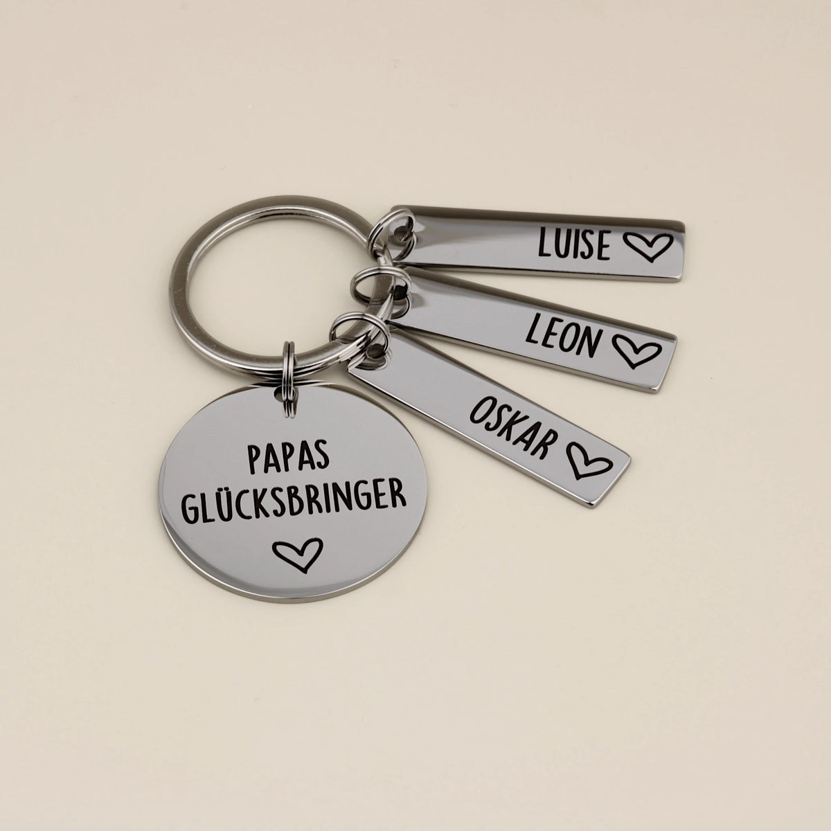 Papas Glücksbringer Schlüsselanhänger mit drei Namensanhängern Luise, Leon und Oskar.
