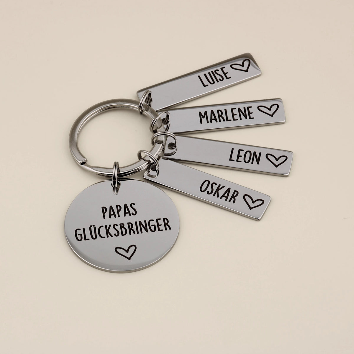 Papas Glücksbringer mit vier Namensanhängern für Luise, Marlene, Leon und Oskar.
