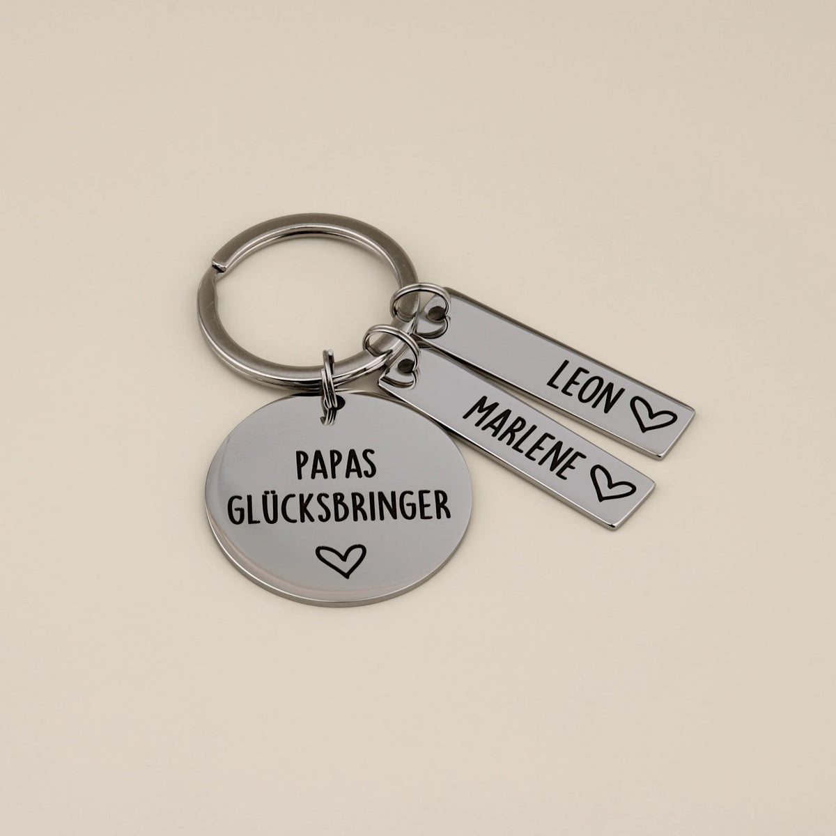 Papas Glücksbringer Schlüsselanhänger mit zwei Namensanhängern Leon und Marlene.
