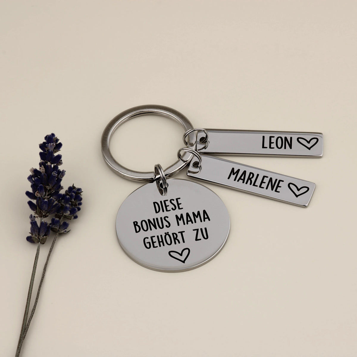 Personalisierter Bonus-Mama-Schlüsselanhänger mit zwei Namensanhängern und Lavendel.