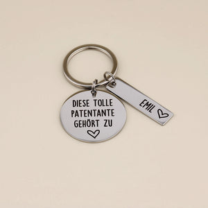 Schlüsselanhänger „Diese tolle Patentante gehört zu“ mit Namensanhänger Emil auf hellem Hintergrund.