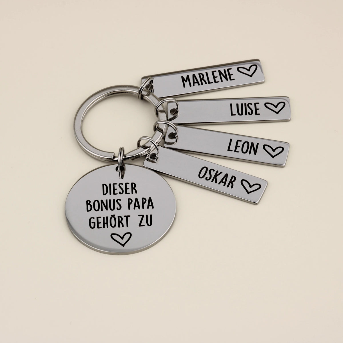 Personalisierter Schlüsselanhänger für den Bonus Papa mit vier Namensplättchen: Marlene, Luise, Leon und Oskar.
