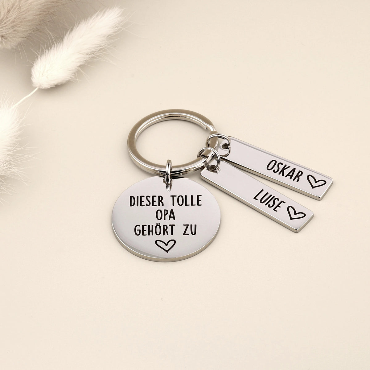 Schlüsselanhänger „Dieser tolle Opa gehört zu“ mit den Namensanhängern Oskar und Luise.