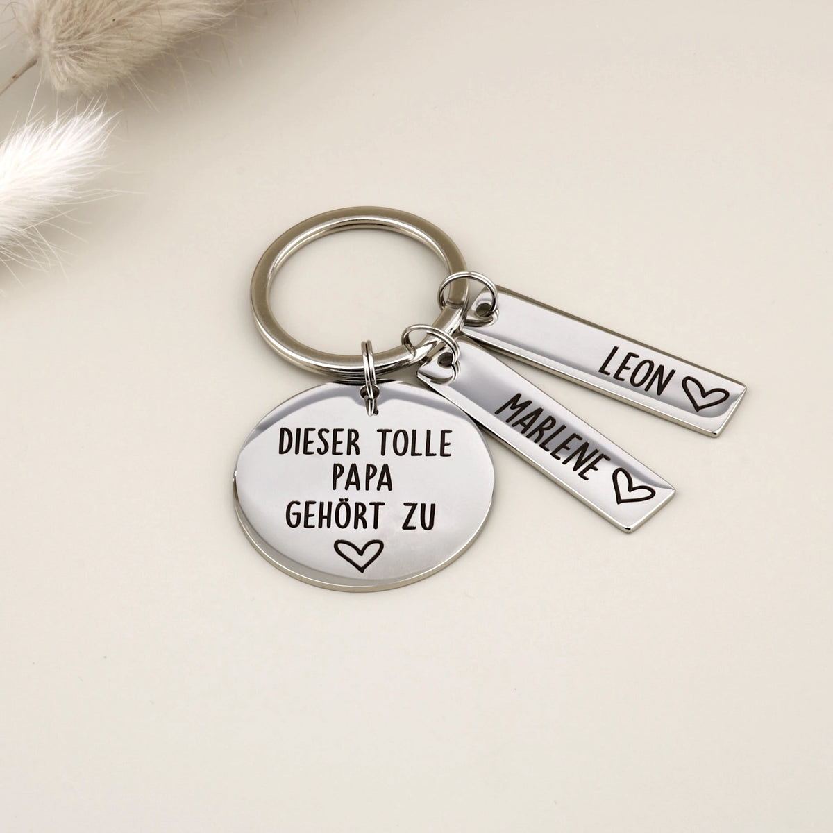Schlüsselanhänger „Dieser tolle Papa gehört zu“ mit zwei Namensanhängern Leon und Marlene.