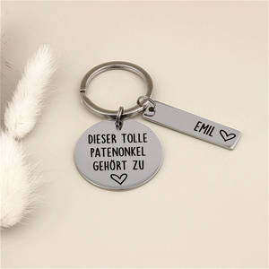 Schlüsselanhänger „Dieser tolle Patenonkel gehört zu“ mit Namensanhänger Emil und heller Dekoration.