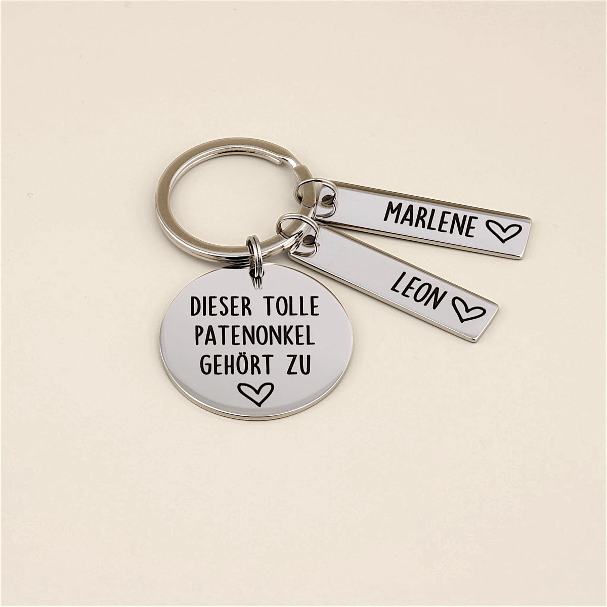 Detailansicht des Schlüsselanhängers „Dieser tolle Patenonkel gehört zu“ mit Namensanhänger Emil.