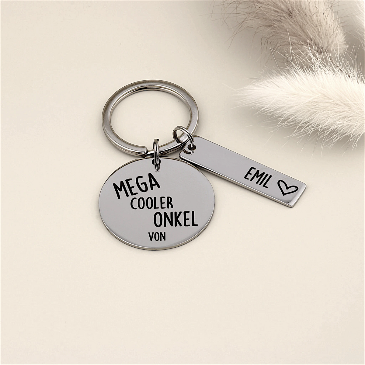 Schlüsselanhänger „Mega cooler Onkel von“ mit Namensanhänger Emil und heller Dekoration.