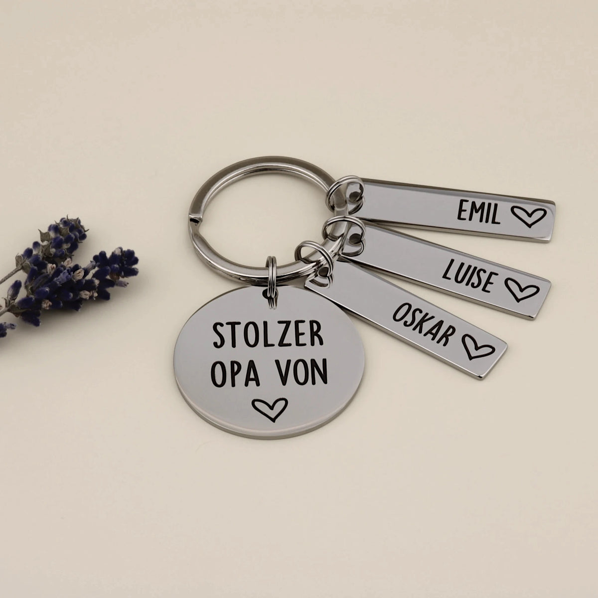 Stolzer Opa-Schlüsselanhänger mit drei Namensanhängern und Lavendel als dekorativem Akzent.
