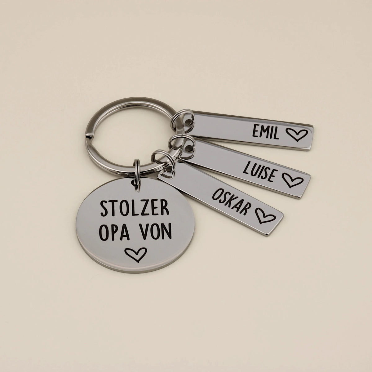 Personalisierter Schlüsselanhänger für Stolzer Opa mit drei Namensanhängern auf hellem Hintergrund.
