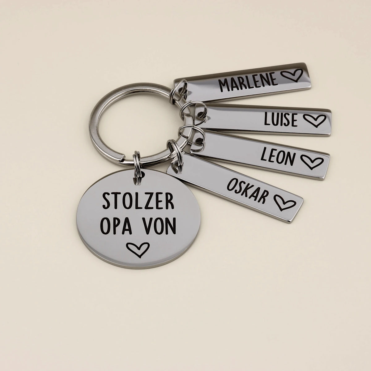 Personalisierter Stolzer Opa-Schlüsselanhänger mit vier Namensanhängern und Herzsymbolen.
