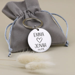 Personalisierter Paar-Schlüsselanhänger von Gravur19 mit grauem Samtsäckchen als Geschenkverpackung zum Jahrestag.