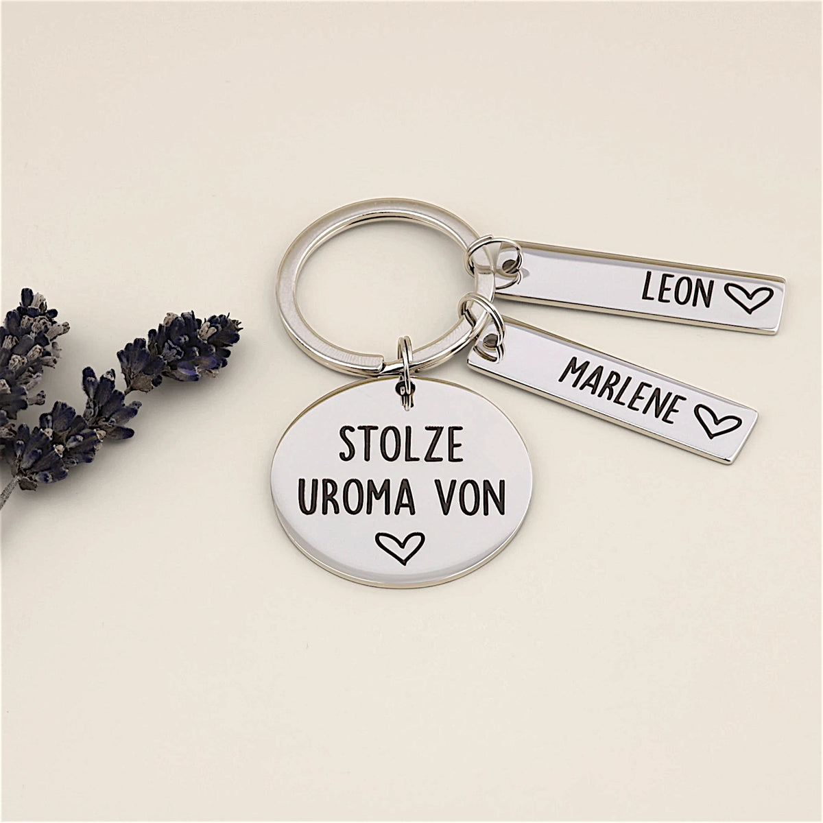 Schlüsselanhänger „Stolze Uroma von“ mit zwei Namensanhängern und Lavendeldekoration.