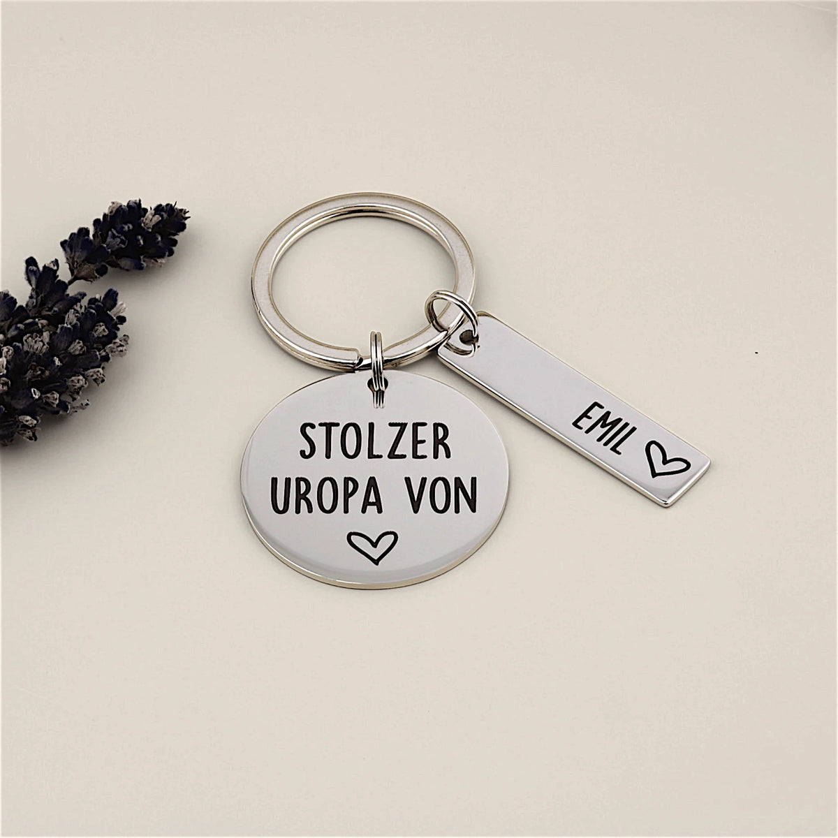 Schlüsselanhänger „Stolzer Uropa von“ mit Namensanhänger Emil neben Lavendel.