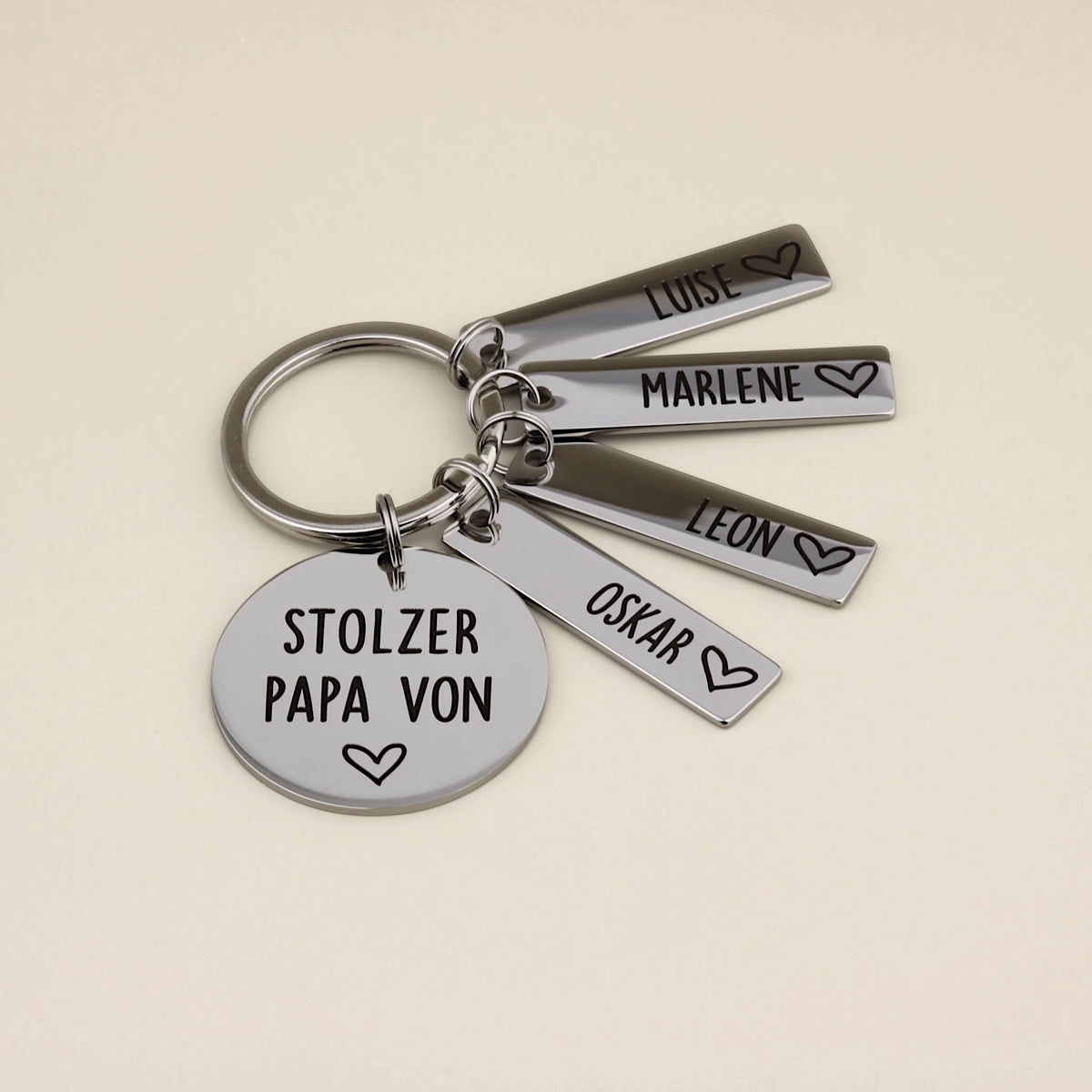 Schlüsselanhänger „Stolzer Papa von“ mit vier Namensanhängern: Luise, Marlene, Leon und Oskar.
