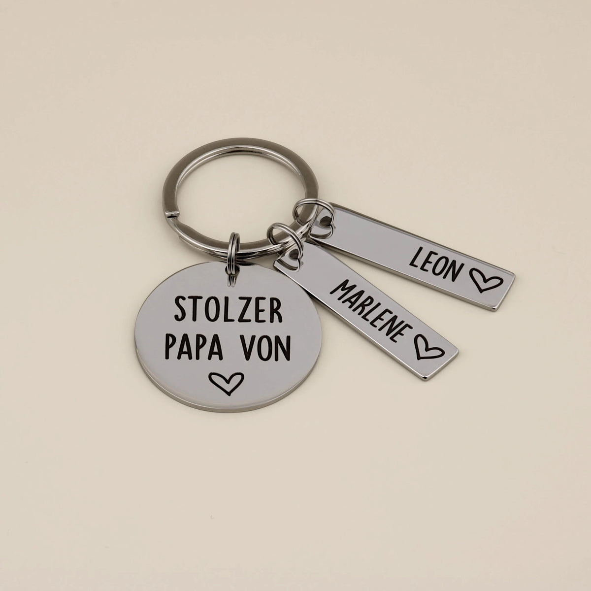 Schlüsselanhänger „Stolzer Papa von“ mit den Namensanhängern Leon und Marlene.
